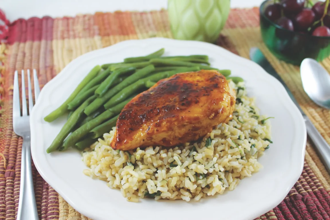 Orange chipotle chicken plated with rice and green beans