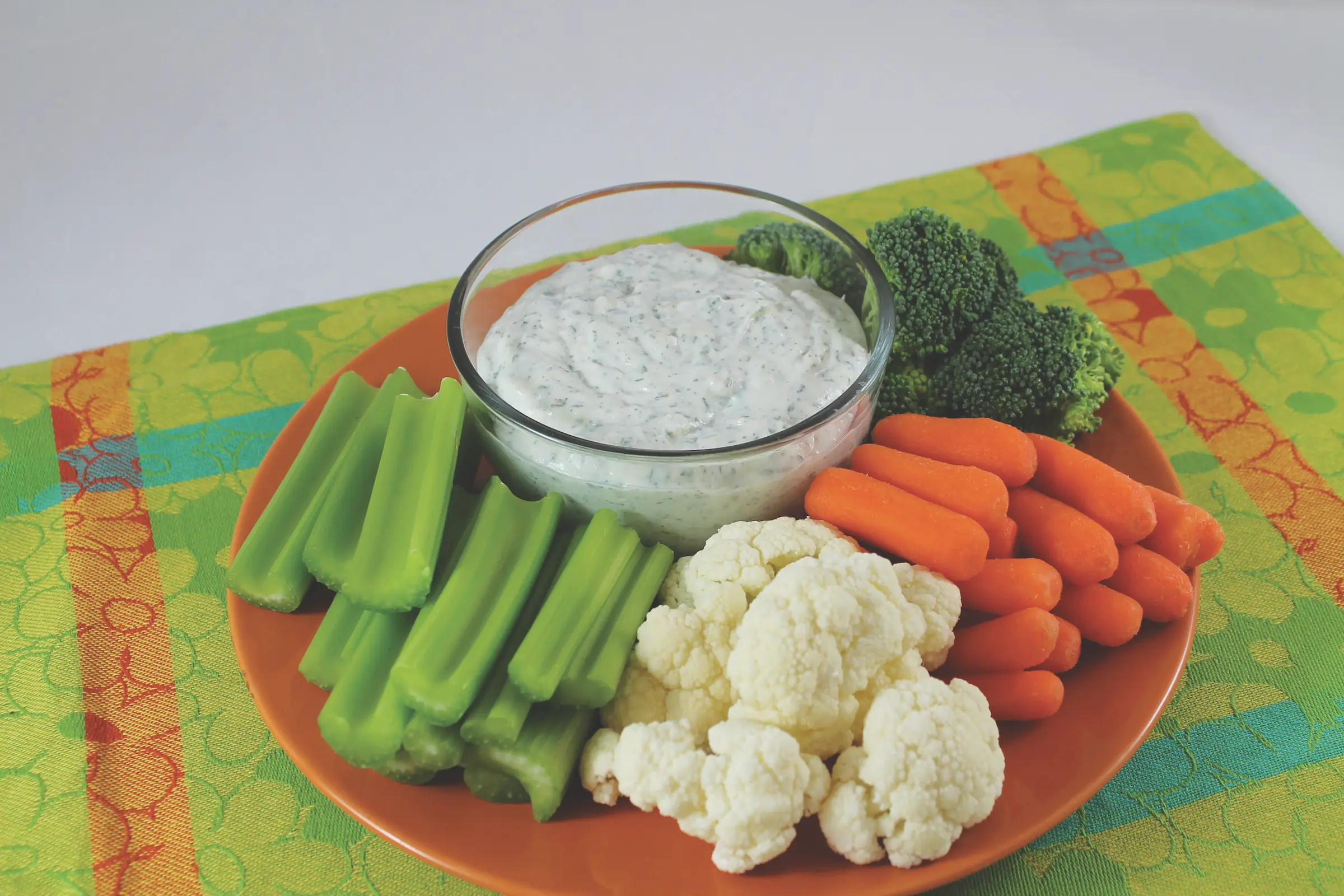 platter of celery, cauliflower, broccoli and carrots with bowl of ranch dip