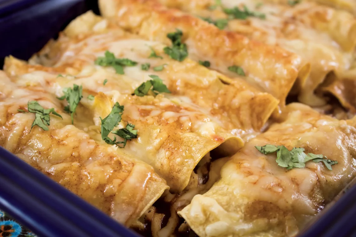 Enchiladas topped with cilantro and cheese.