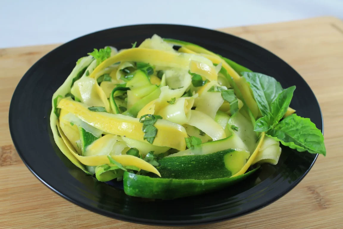 Shredded squash topped with basil in a bowl.