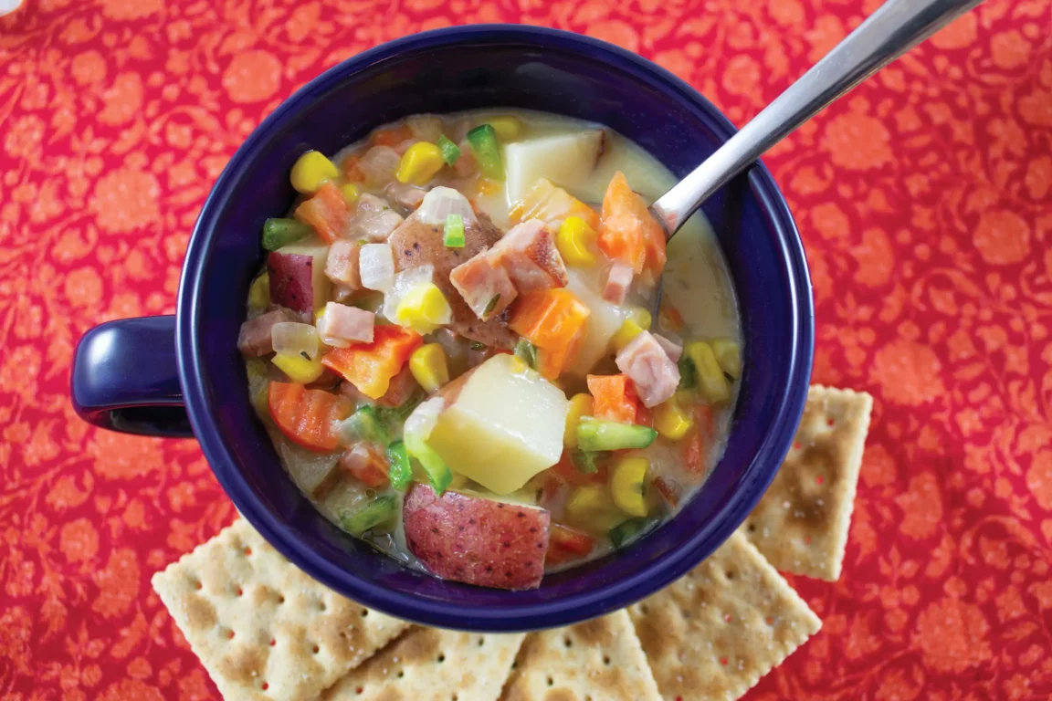 Ham and corn chowder plated with a side of crackers