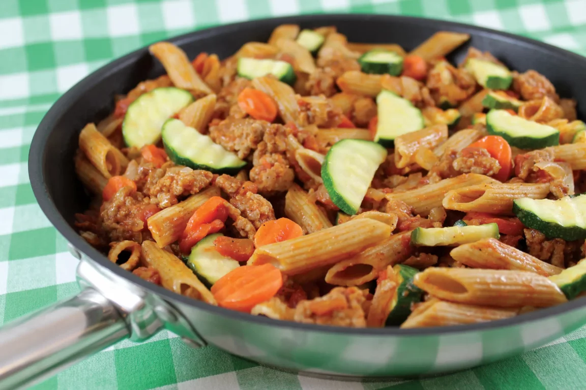pork and pasta plated in a skillet