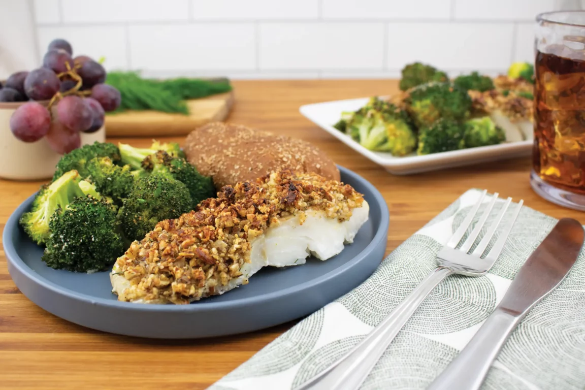 Citrus almond crusted fish plated with broccoli 