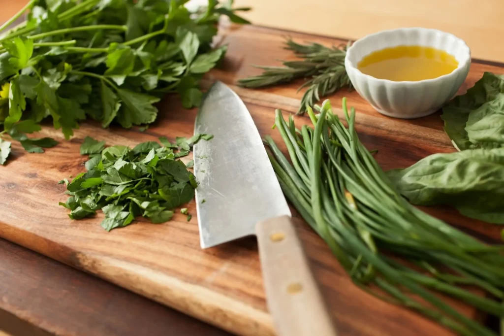 Knife on a cutting board with fresh greens. 