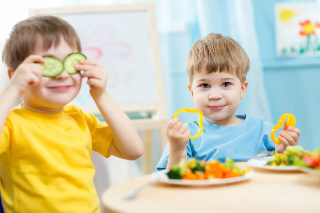 Kids playing with veggies.